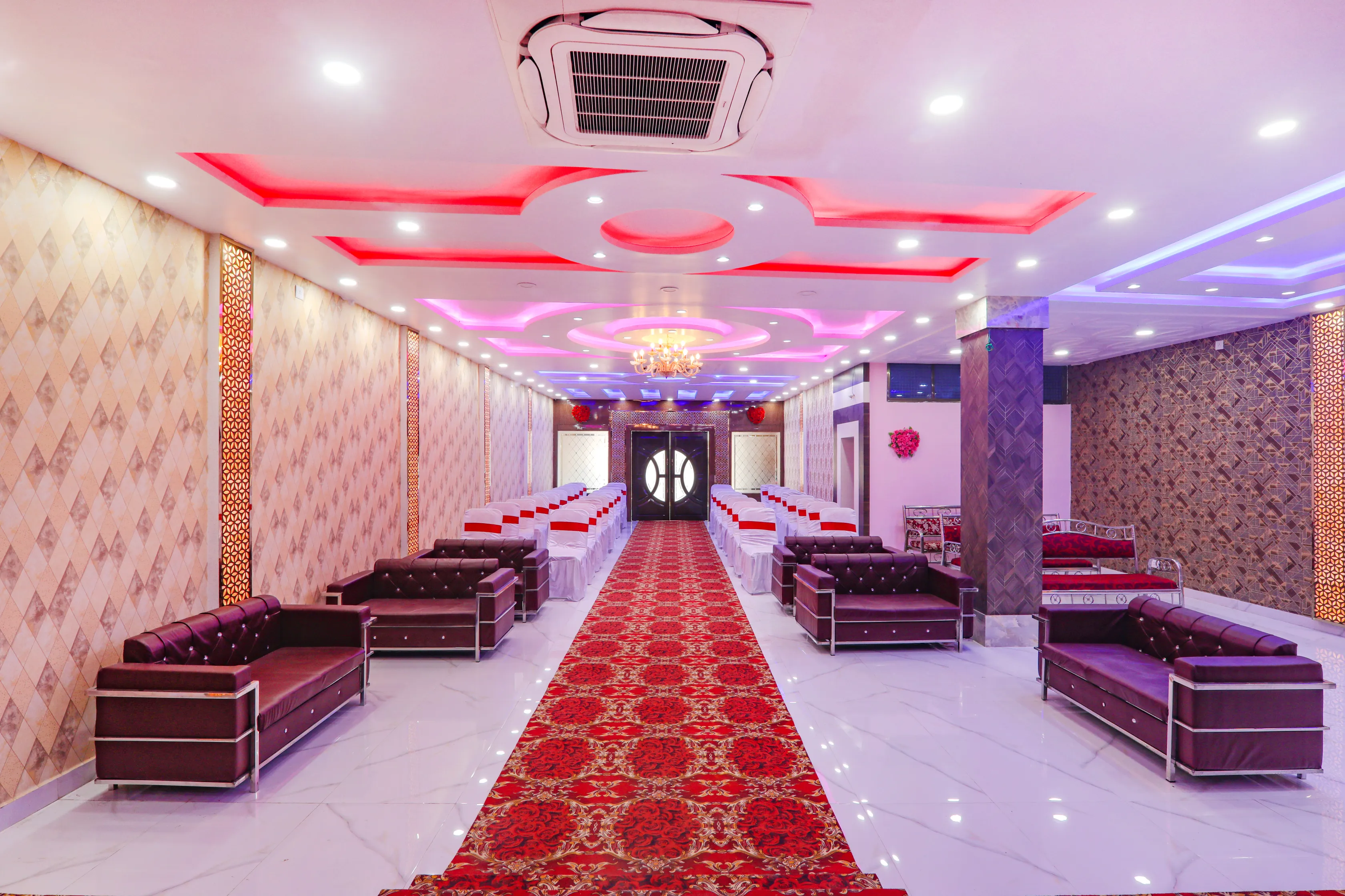 Banquet hall lounge with sofas and red carpet aisle for wedding guests